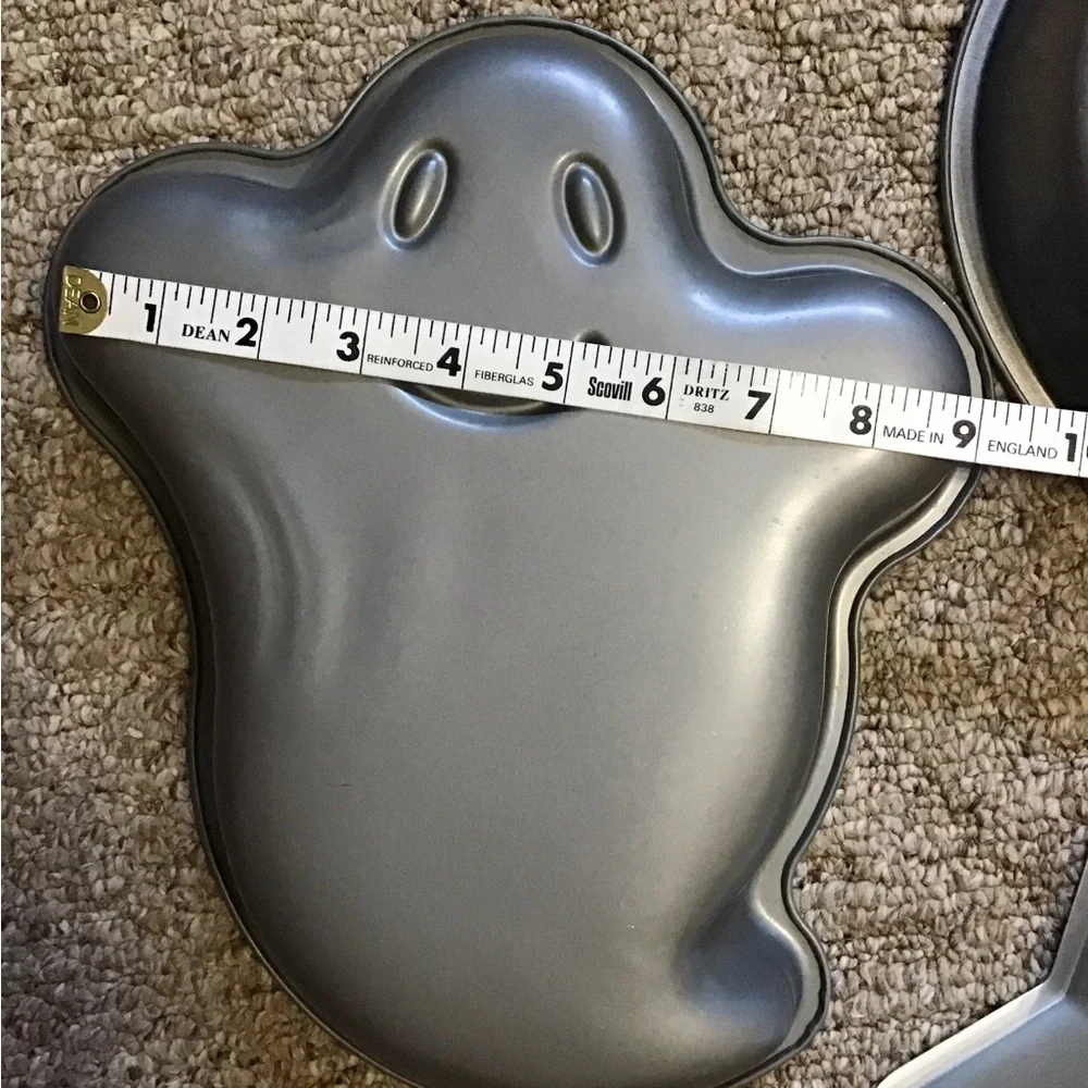 A total of 3 cake pans one star, one ghost , one pumpkin
